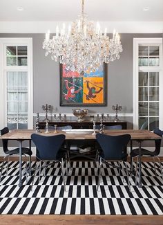 a dining room with a chandelier and checkered rugs on the floor