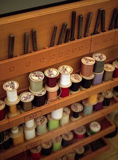 many spools of thread are on the shelf next to each other with numbers