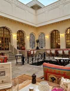 a room filled with lots of tables and chairs next to each other in front of windows