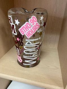 a clear glass cup sitting on top of a wooden shelf