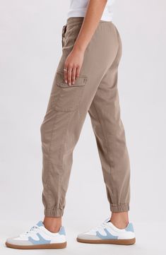 An adjustable drawstring cinches the waist of these cargo-style joggers crafted from a soft cotton blend. 28" inseam; 9-13" leg opening; 10" front rise (size S) Drawstring waist Side cargo pockets Elastic hem 60% cotton, 38% rayon, 2% spandex Machine wash, tumble dry Imported Model Stats: 5'10" height; 34" bust; 27" waist; 35" hips. Model is wearing size S. Khaki Utility Cargo Jeans With Elastic Waistband, Casual Mid-rise Cargo Pants With Elastic Waistband, Khaki Utility Joggers With Cargo Pockets, Khaki Utility Cargo Joggers, Casual Cargo Pants With Elastic Waistband And Cuffed Ankles, Cargo Style, Cargo Joggers, Drawstring Waist, Tumble Dryer