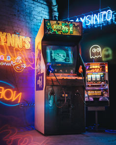 an arcade machine sitting in front of a neon sign that says lynn's casino