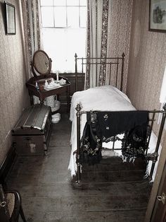 a bedroom with a bed, dresser and mirror on the wall next to a window