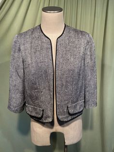 This is a classic vintage cropped dress jacket from the 60s or early760s.  No label. Tagged a size 16. The bust measures 40", see measurements below.  Made of a wool blend in a black & white herringbone pattern. The jacket is not lined in the body, but not the sleeves.  It has 3/4 length sleeves & faux pocket flaps. It is cropped, reaching the natural waist. Made without closures. There are small shoulders pads inside the shoulders.  The hem & edges are all trimmed in black braid trim The jacket is in good condition, no soil or stains. Looks like there are two small repairs to the weave on the right side front, which are hard to see. Measurements were taken with the garment lying flat & the bust, hip & waist measurements were doubled for the measurements below. If you have never worn vinta Classic Cropped Jacket For Spring Evenings, Retro Fitted Cropped Outerwear, Fitted Retro Cropped Outerwear, Vintage Formal Tweed Jacket For Spring, Vintage Tailored Career Outerwear, Tailored Vintage Career Outerwear, Fitted Vintage Cropped Jacket, Vintage Cropped Fitted Outerwear, Vintage Cropped Outerwear For Work