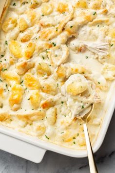 a casserole dish with chicken and dumplings in it on a marble surface