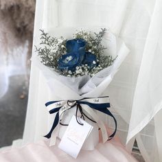 a bouquet of blue roses wrapped in white paper