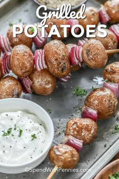 skewered meat and vegetables on a tray with dip