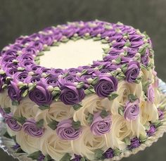 a cake decorated with purple and white roses