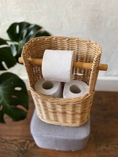 two rolls of toilet paper in a wicker basket