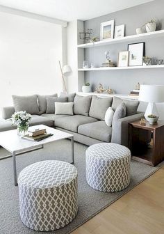 a living room filled with lots of furniture and white shelves on the wall behind it