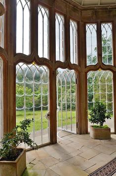 the inside of a building with large windows and potted plants in front of them