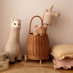 two stuffed animals sitting next to a wicker basket with a lamp on top of it