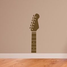 a guitar wall sticker on the wall in a room with hardwood floors and walls