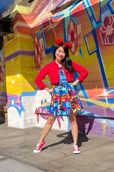 a woman standing in front of a colorful wall