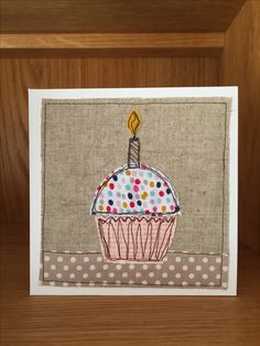 a birthday card with a cupcake on the front and a candle in the middle