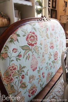 an upholstered headboard with flowers on it in a living room next to a window