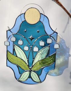 a stained glass sun catcher hanging from a tree branch