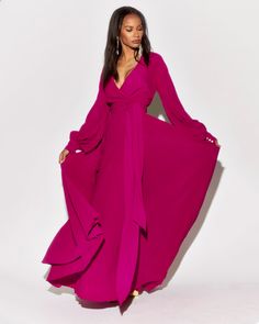 This 70's inspired maxi dress features a sexy cross front V-shaped surplice neckline. The elasticized waist adjusts to fit a range of sizes and has an attached self-tying belt at the right-hand side seam. The cuffed bell sleeves add a hint of retro glamour. The opaque fabric has a butter-soft hand with vibrant cranberry hue. The full, sweeping circle maxi skirt is perfect for making a dramatic entrance to any event. The skirt is partially lined. ** Based on the settings of your display, colors m Wrap Maxi Dress Long Sleeve, Circle Maxi Skirt, Dramatic Entrance, Retro Glamour, Long Sleeve Gown, Surplice Neckline, Flowing Skirt, Medium Dress, Mid Length Skirts