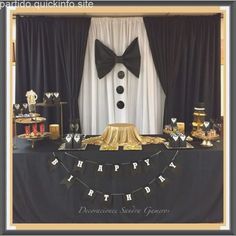 a black and gold birthday party with cake, desserts, and decorations on the table