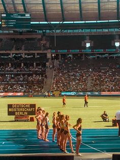 a group of women standing on top of a blue track