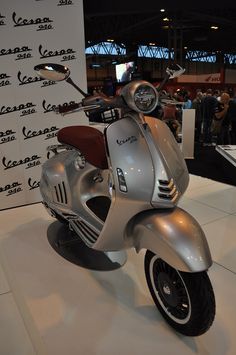 a silver scooter is on display at a show