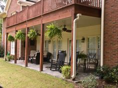 an outside view of a house with chairs and potted plants on the front porch