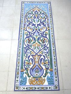 a blue and white tile floor with an intricate design on the bottom part of it