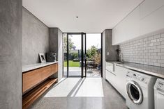 a laundry room with washer and dryer next to glass doors that lead outside