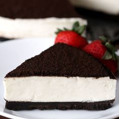 a slice of cheesecake with chocolate and strawberries on the side sitting on a white plate