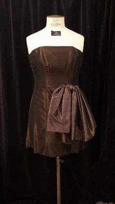 Short strapless dress, mini skirt, in chocolate brown taffeta, with large shiny copper tulle bow, longer at the back, XL, TULIPE Bow TULIPE cocktail dress or short evening dress in chocolate synthetic taffeta with orange highlights, a little longer at the back than at the front and a copper brown tulle bow. Soft bones in the bodice, and antistatic lining. Size XL (chest 102 cm/ waist 90 cm/ hips 115 cm/ front length 71 cm/ back length 85 cm) Unique piece. Possible alterations to fit perfectly to Short Strapless Dress, Short Evening Dress, Orange Highlights, Strapless Dresses Short, Tulle Bow, Tulle Bows, Copper Brown, Evening Dresses Short, Dress Clothes For Women