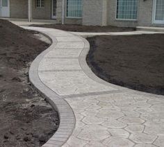 a house that is in the middle of some dirt and has a walkway going up to it