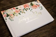 an open wedding album with flowers on it