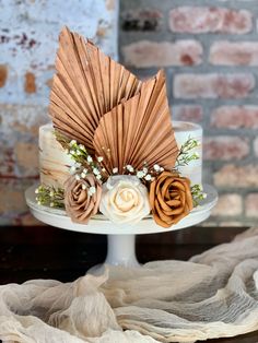 a cake decorated with flowers on top of a white plate next to a brick wall