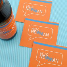 three orange business cards with the words hello newnan on them next to an orange bottle