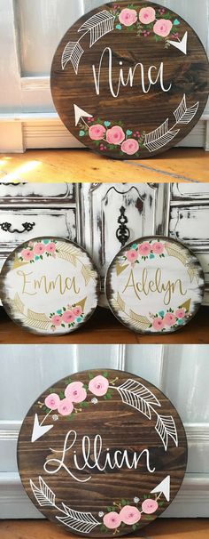 three wooden signs with flowers and arrows painted on them, one has the word's name