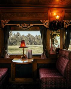 the inside of a train car with two couches and a table in front of it