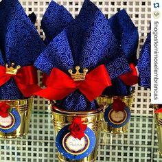 there are many blue and red napkins in gold cups with bows on the top