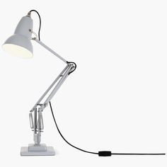 a white desk lamp with a black cord attached to the base and an arm that is plugged into it