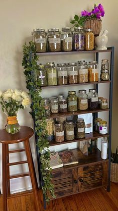 a shelf filled with lots of jars and flowers