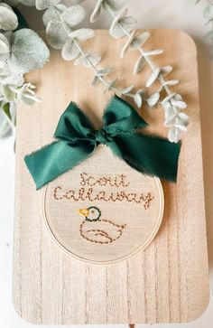 a cross stitch ornament with a green bow on it