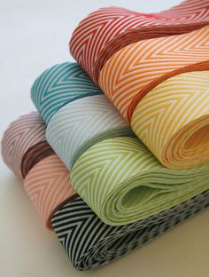 a stack of multicolored cloths sitting next to each other on a table