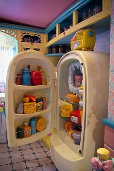 an open refrigerator in the middle of a kitchen filled with dishes and condiments