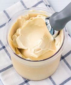 a spoon is in a container filled with icecream on a checkered tablecloth