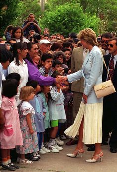 a woman shaking hands with a crowd of people