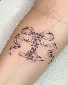 a woman's leg with a tattoo on it that has a hat and bow