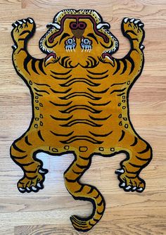 a wooden floor with a drawing of a tiger on it's back and arms in the air