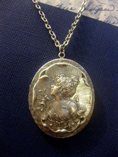 "Lady Of Eden Metal Portrait Locket Pendant Necklace Open and close locket with metal portrait of a graceful lady. Measurements: Necklace chain measures 22 inches. (for different chain lengths, read below \"measurements\" section). The open and close locket measures 47mm x 38mm (1.8 in x 1.5 in). FOR LENGTH ADJUSTMENTS: I can shorten, or extend the length of this necklace up to 28\" free of charge. If you would like the length of this necklace extended beyond 28\" there will be an extra charge o Silver Cameo Medallion Necklace, Victorian Cameo Necklace For Memorial, Silver Cameo Metal Necklace, Silver Metal Cameo Necklace, Silver Cameo Jewelry For Memorial, Vintage Coin Pendant Necklace For Wedding, Vintage Wedding Necklace With Coin Pendant, Vintage Wedding Coin Pendant Necklace, Elegant Engraved Metal Locket Necklace