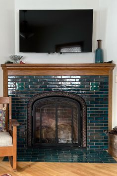 a living room with a fire place and television on the wall above it's fireplace