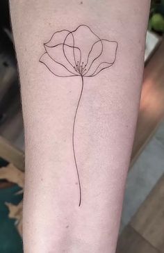 a single flower tattoo on the arm