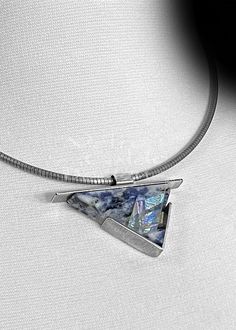 This stunning Blue-Jean Sodalite, Cold-Worked Optical & Dichroic Glass, Etched Metal, Oxidized Sterling Silver, Hand Fabricated, statement pendant.  The setting is sterling silver, with an oxidized patina.  Marc has cut and lapped the stone to this shape, created the fused dichroic glass, and married the two together. Wendy hand fabricates all the silver setting. THIS LISTING IS FOR THE PENDANT ONLY! 📖 Product Information: ~ Item/Material: Blue-Jean Sodalite, Cold-Worked Optical & Dichroic Glass, Etched Metal, Oxidized Sterling Silver ~ Length: 1.25" ~ Width: 2.00" The VCD jewelry lines, consists of natural stone, optical glass, fused glass, cast glass, dichroic glass, and/or a hybrid marriage of natural stone and glass.  All are set in sterling silver (.925). Some larger items may also i Metal Etching, Setting Ideas, Cast Glass, Glass Fusing, Teardrop Pendant, Statement Pendant, Dichroic Glass, Oxidized Silver, Oxidized Sterling Silver